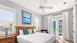A bedroom with a bed, nightstands, a ceiling fan, and a window with blinds.