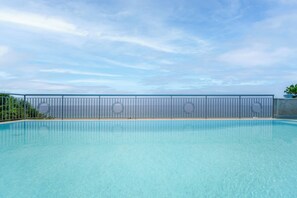 Relax by the serene pool surrounded by lush greenery and an atmosphere.