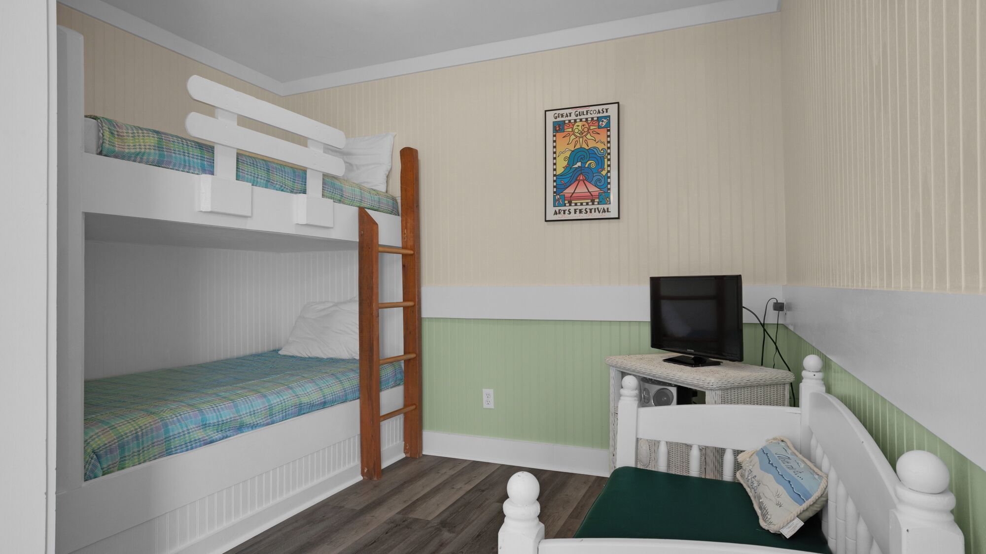 Une chambre avec un lit superposé, une télévision et une affiche accrochée au mur.