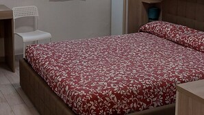 Une chambre à coucher avec un lit, un bureau et une chaise.