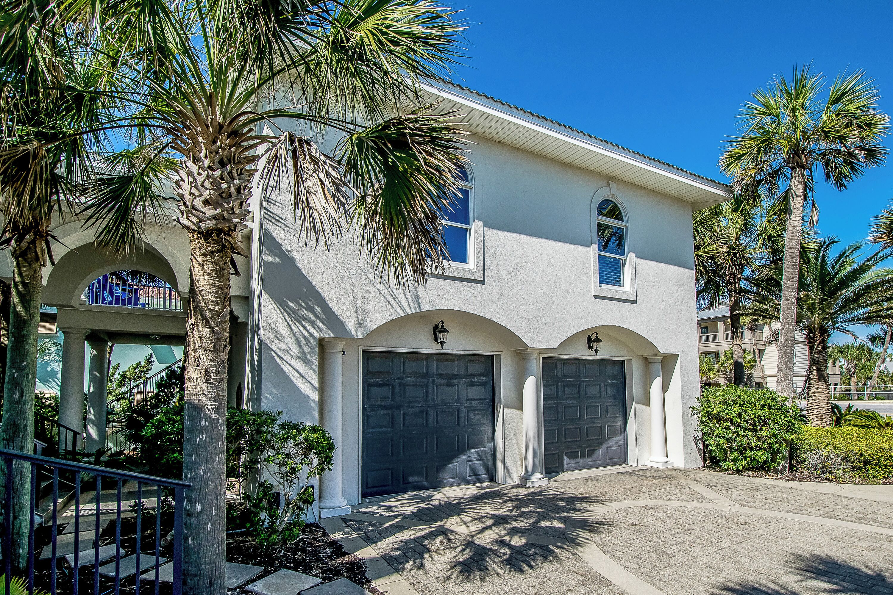 A two-story house with a white exterior, a covered driveway, and a front porch.