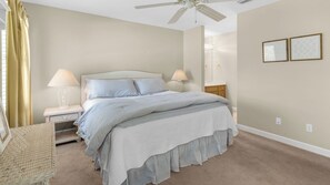 A bedroom with a bed, two bedside tables, a chair, a ceiling fan, and two wall-mounted lamps. - Coastal Getaway - Beach, Pool, Golf Cart, Seagrove Beach! (Santa Rosa Beach)