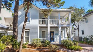 A two-story house with a front porch, a blue door, and a balcony. - Coastal Getaway - Beach, Pool, Golf Cart, Seagrove Beach! (Santa Rosa Beach)