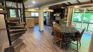 A spacious kitchen with a dining area, a staircase, and a view of the outdoors. - 6 Bed River Home, Right On St. Joseph River. (Union City)