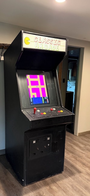 A classic arcade machine with a neon sign, joystick, buttons, and a screen displaying a game.