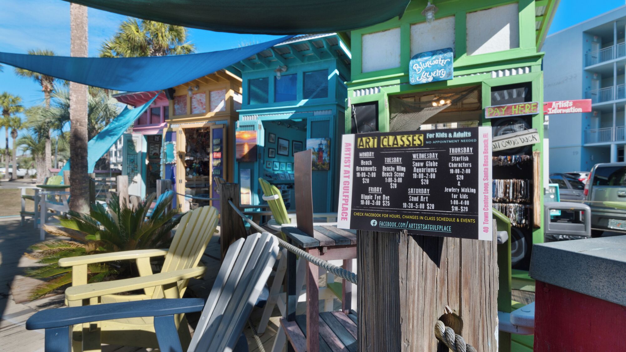 A colorful outdoor seating area with a sign for artist classes.