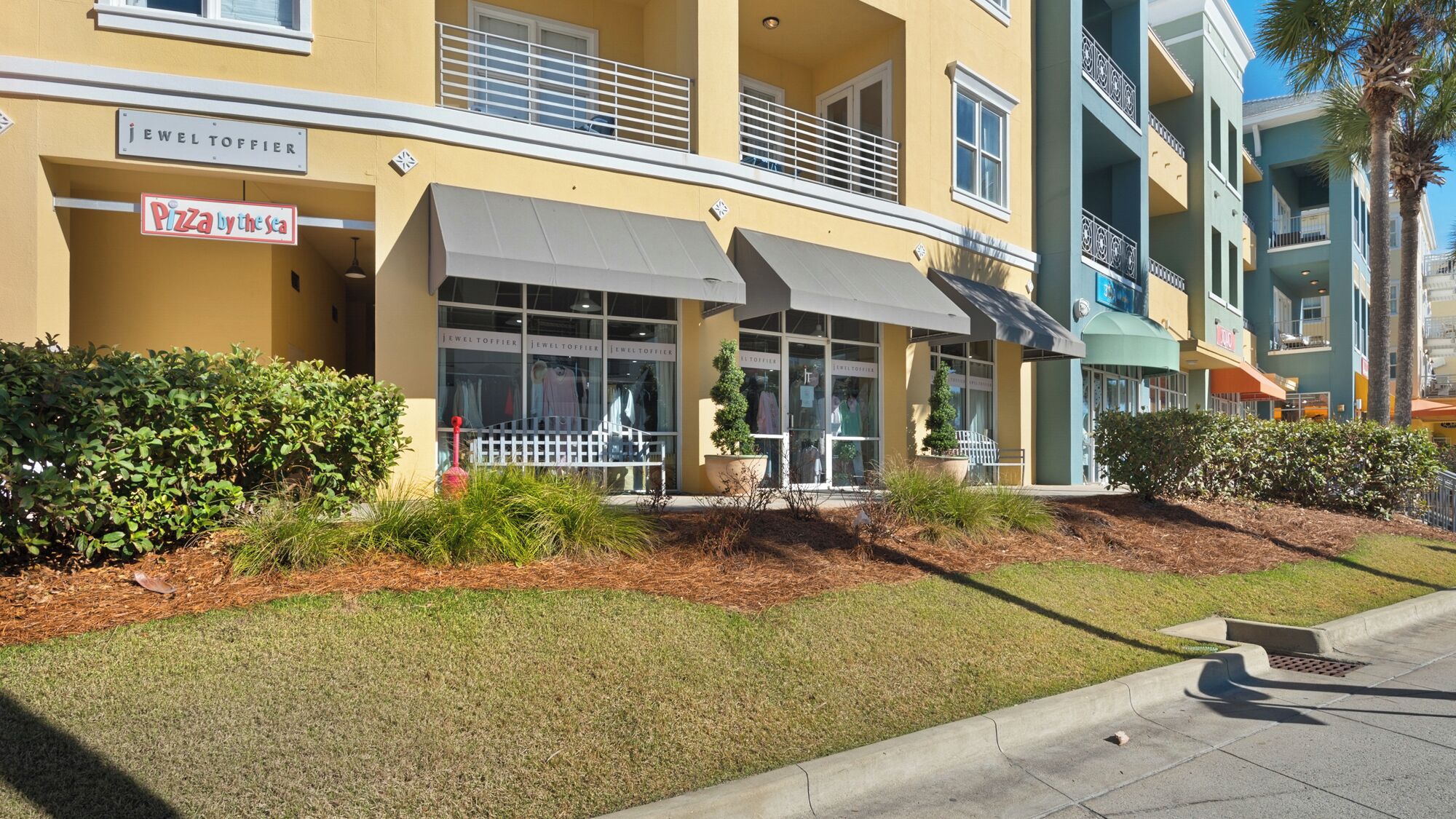 A building with a storefront named 'Pizza by the sea' and a jewelry store named 'Jewel Toffier'.