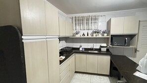 A compact kitchen with a microwave, sink, and cabinets. - Marinas Tamandaré próximo à Carneiros  (Tamandaré)