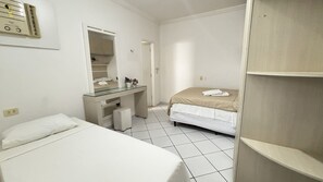 Una habitación pequeña y limpia con cama, escritorio, espejo y armario.