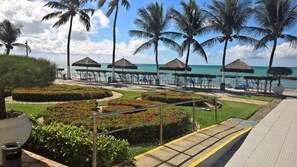 A beachside resort with palm trees, thatched-roof gazebos, and a paved walkway leading to the beach. - Marinas Tamandaré próximo à Carneiros  (Tamandaré)