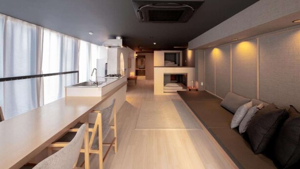 A modern interior with a kitchen, dining area, and a cozy seating space with a fireplace.