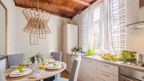 Une cuisine moderne avec une table de salle à manger ronde, des chaises grises et un luminaire suspendu.