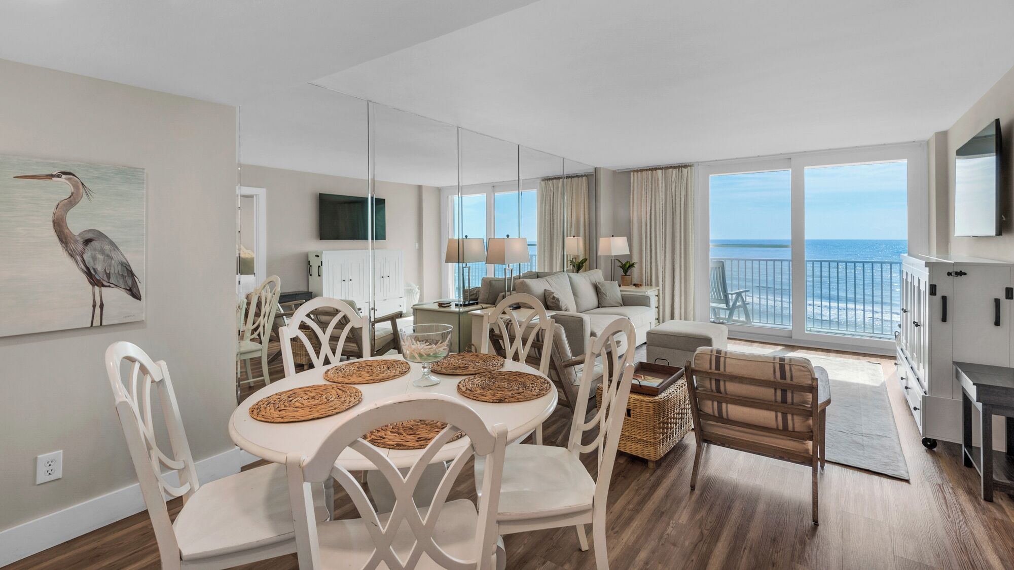 Een moderne woonkamer met een eethoek, grote ramen en uitzicht op de oceaan.