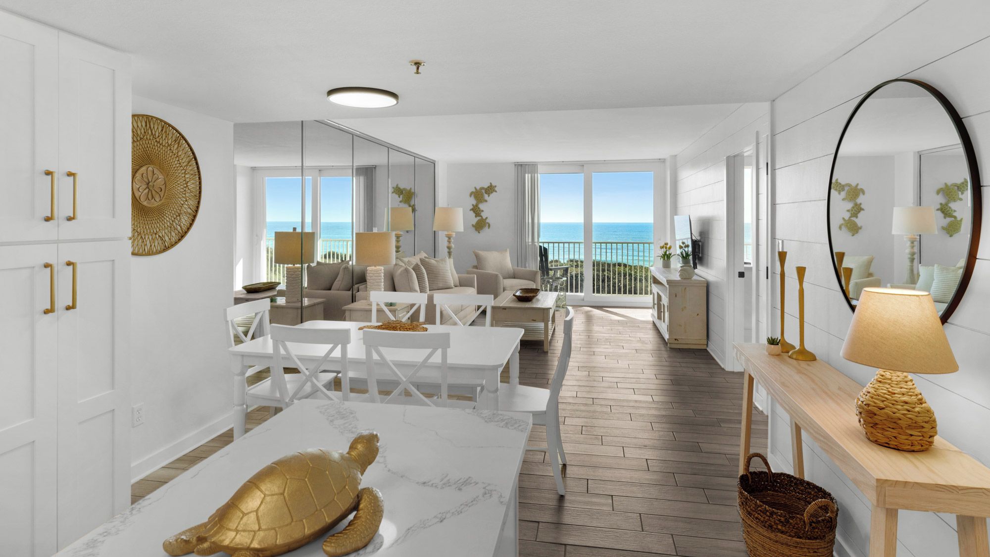 A spacious living area with a view of the ocean, a dining table with a turtle sculpture, and a balcony with a view.