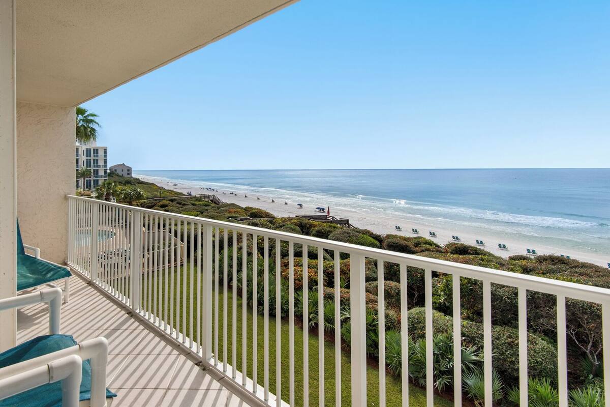 A balcony with a view of a beach and ocean.