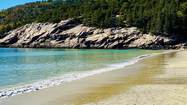 A beach with clear turquoise water, sandy shore, and a forested hill in the background. - Hard Aground - Ocean View Cottage in Southwest Harbor! Pet Friendly!!!  (Southwest Harbor)