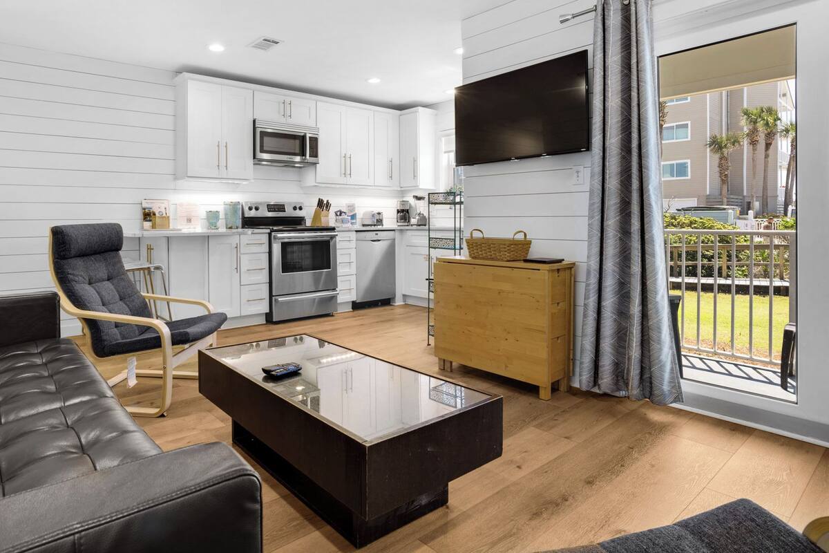 A modern living room with a leather sofa, a glass coffee table, and a wooden cabinet.