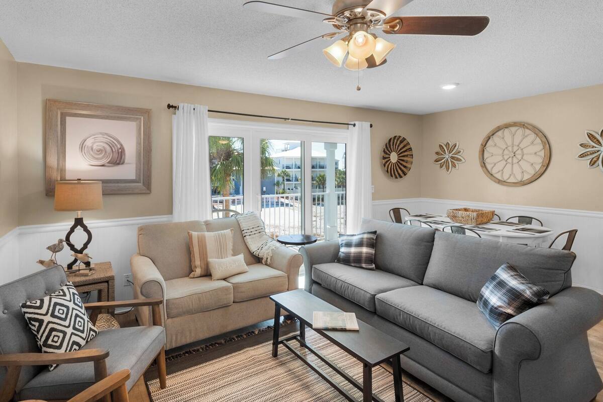 A living room with a sofa, armchair, coffee table, and a dining area with a table and chairs.