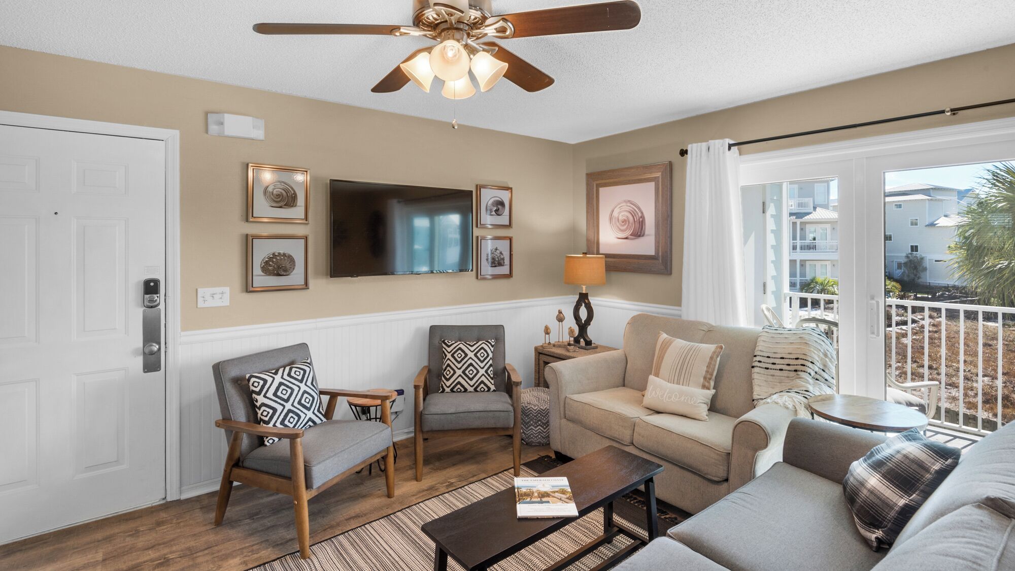 A living room with a ceiling fan, a flat-screen TV, and a sofa.