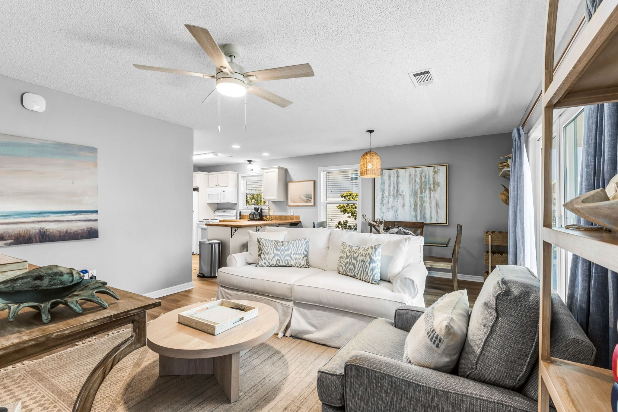 A modern living room with a sofa, coffee table, and ceiling fan.