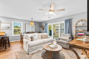 A living room with a sofa, chairs, a coffee table, a ceiling fan, and a view of the outdoors. - Beachside Villas (Santa Rosa Beach)