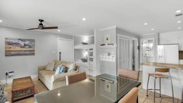 A modern kitchen with white cabinets, a built-in oven, and a stainless steel refrigerator.