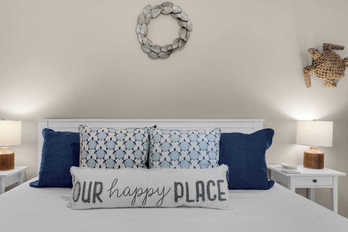 A neatly arranged bedroom with a bed, two bedside tables, and a wall-mounted decorative item.