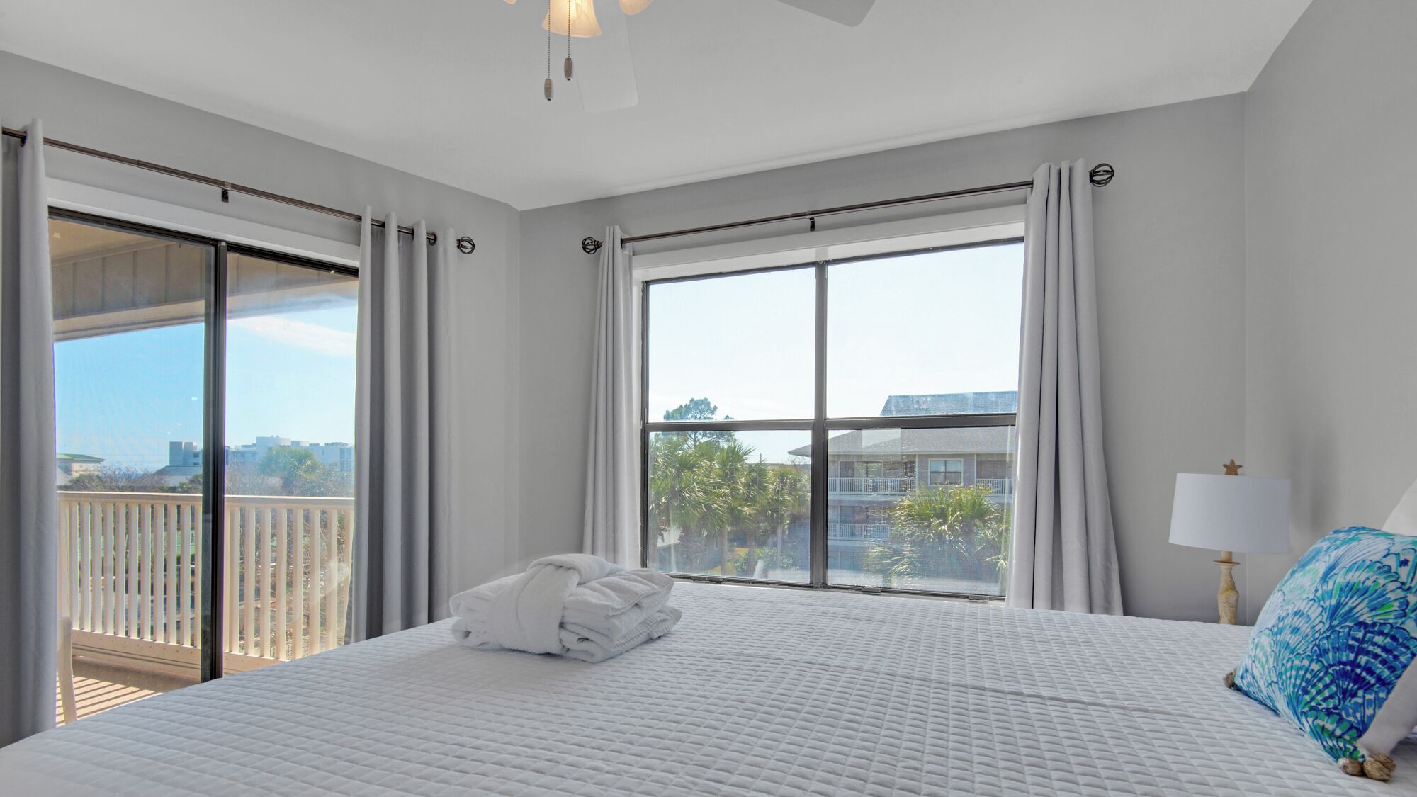 A hotel room with a large bed, a view of the city, and a balcony.