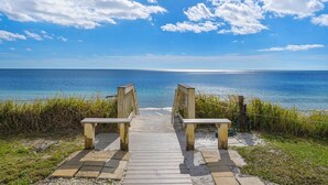 A wooden boardwalk leading to a beach with a clear view of the ocean. - Blue Tide (Panama City Beach)
