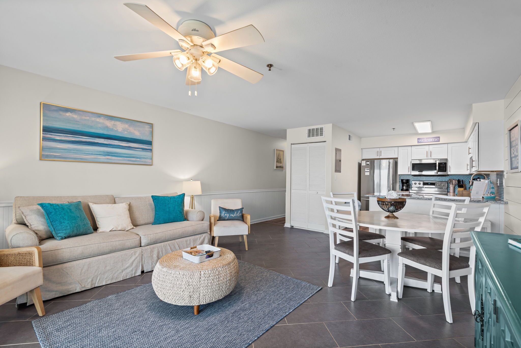 A modern living room with a sofa, coffee table, and a dining area with chairs and a table.