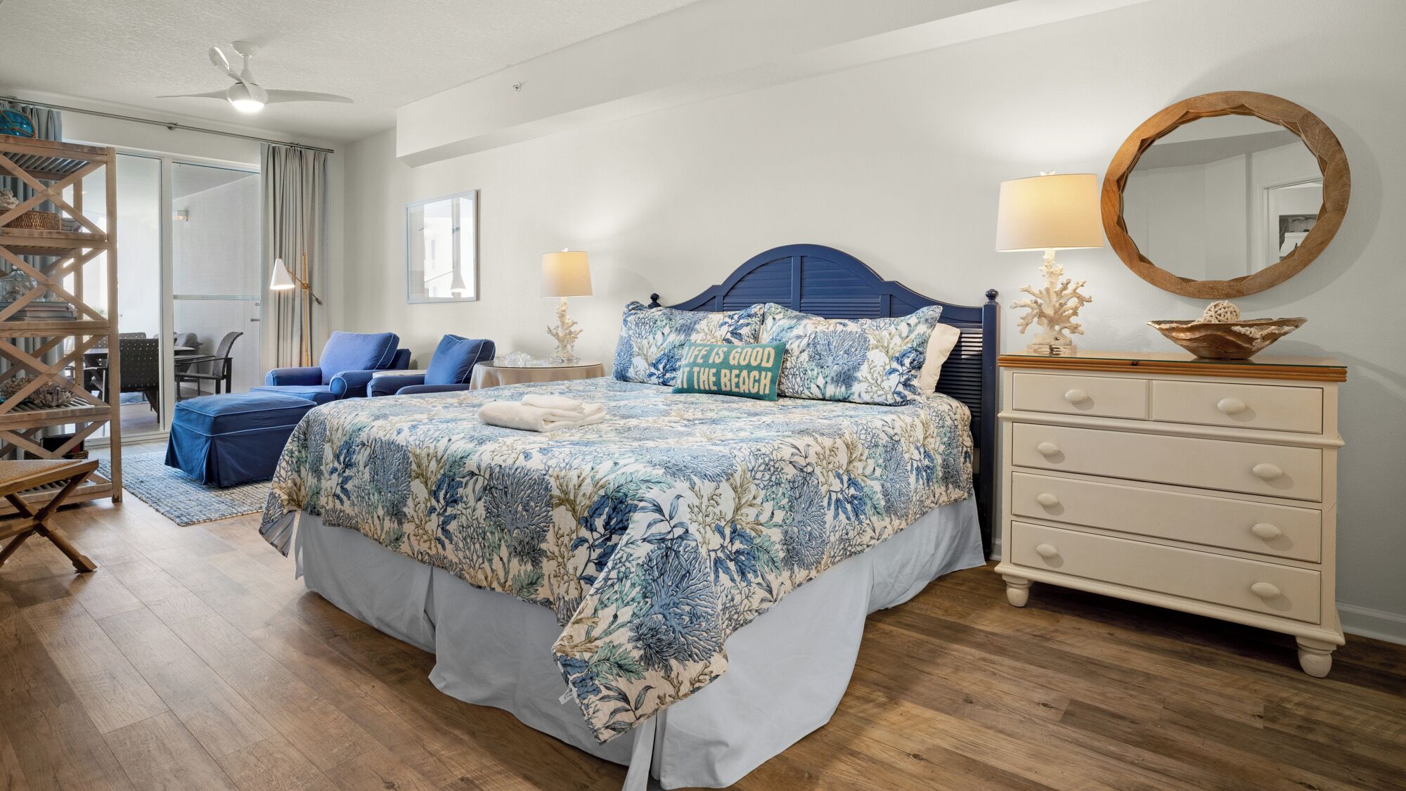 A bedroom with a bed, a dresser, a mirror, and a chair.