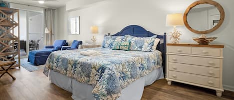A bedroom with a bed, a dresser, a mirror, and a chair.