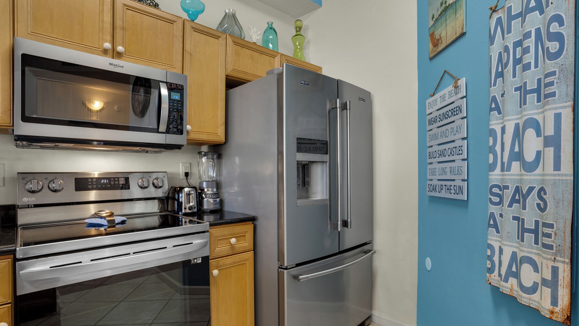 A kitchen with a stainless steel refrigerator, microwave, and oven.