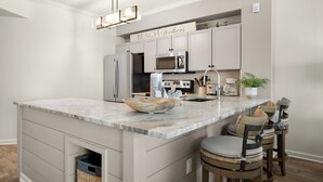 A kitchen with a marble countertop, stainless steel appliances, and a sign reading "BEACH Walkers". - Dunes Of Seagrove (Santa Rosa Beach)