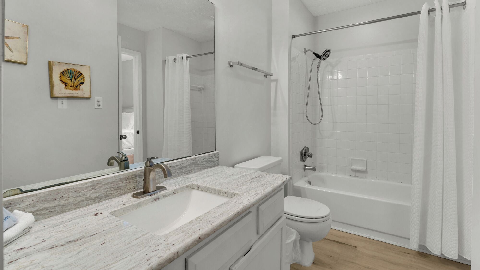 Ein modernes Badezimmer mit Marmorwaschbecken, Toilette und begehbarer Dusche.