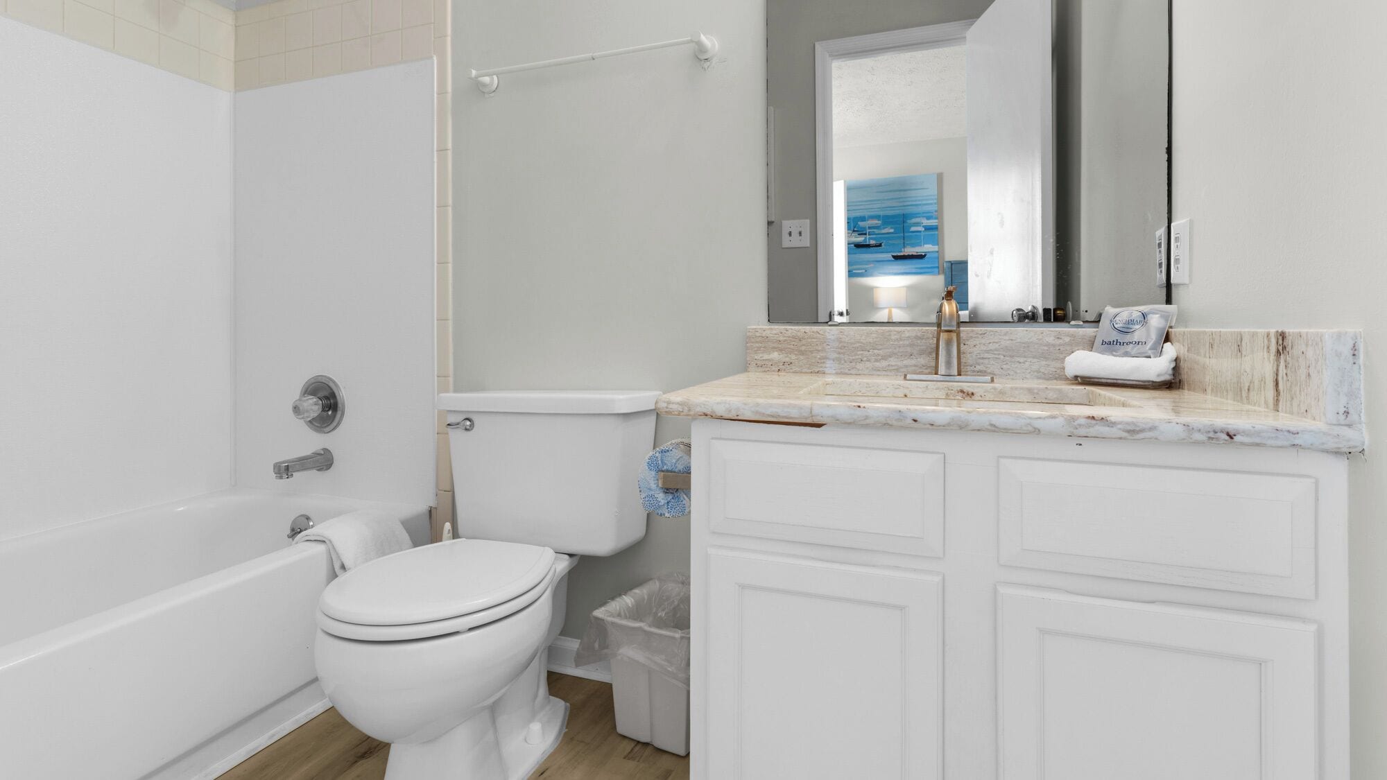 A modern bathroom with a bathtub, toilet, and vanity.