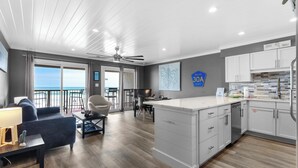 Une chambre d’hôtel moderne dotée d’un balcon, d’un coin repas et d’une cuisine.