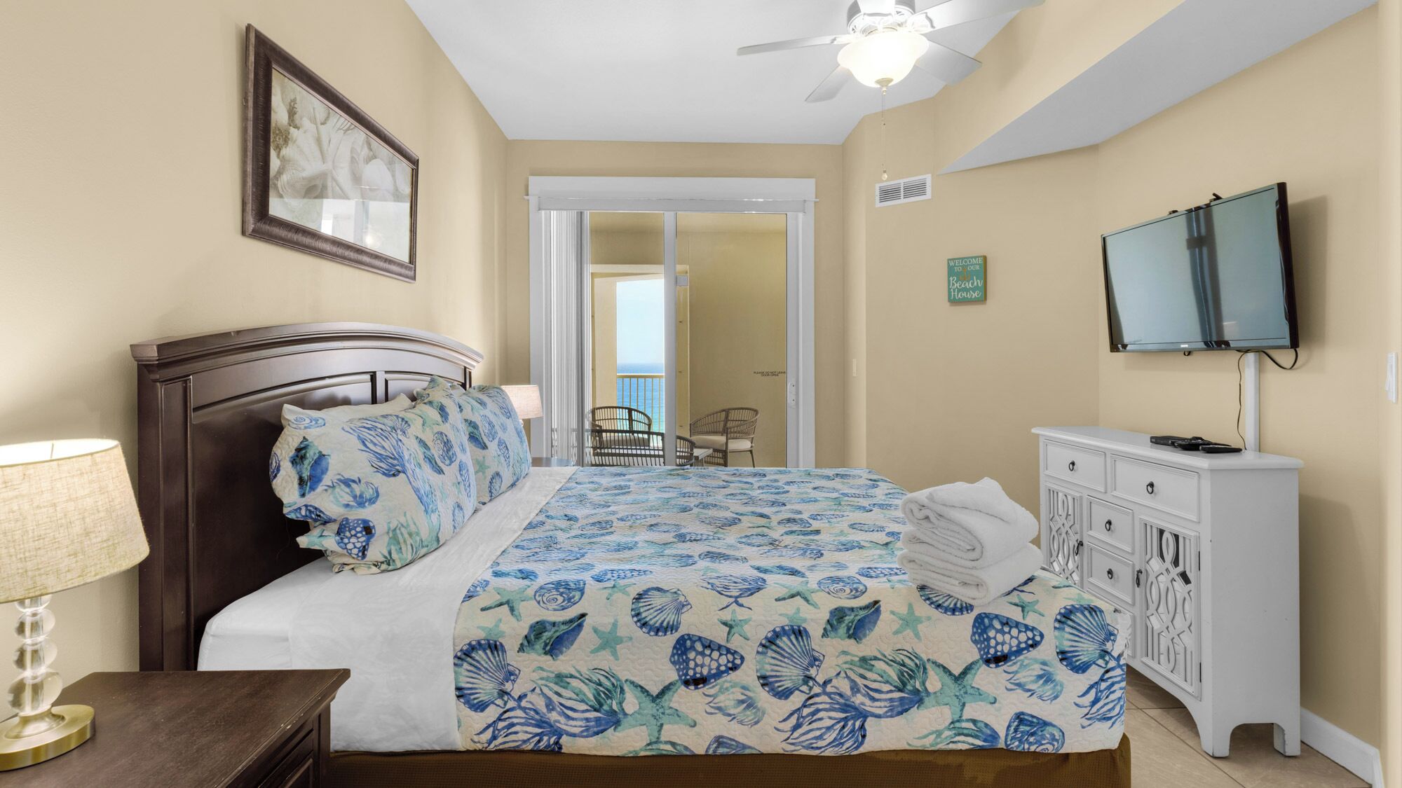 A bedroom with a bed, a TV, a desk, and a chair.