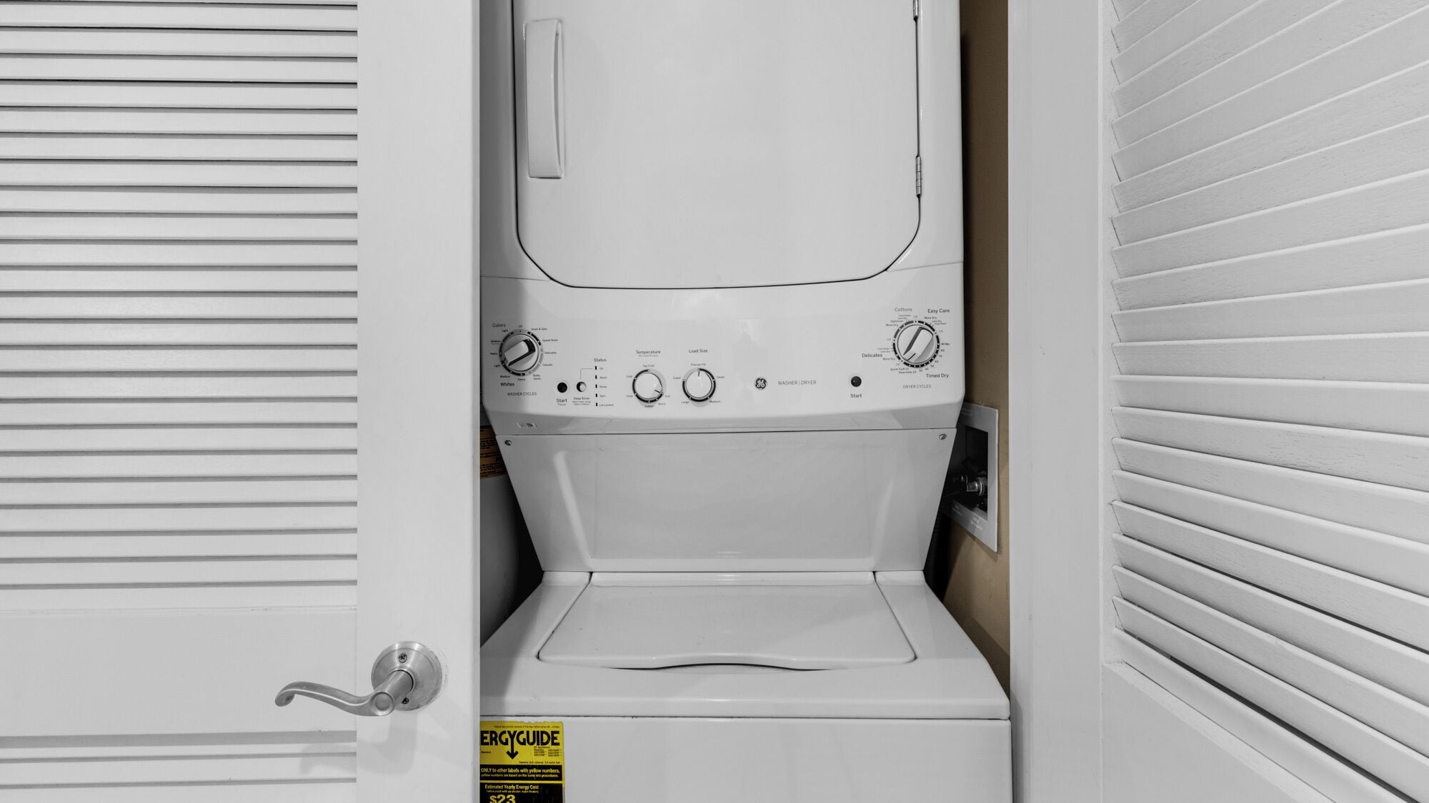 A compact washer and dryer unit with a control panel, a door handle, and an ENERGYGUIDE sticker.