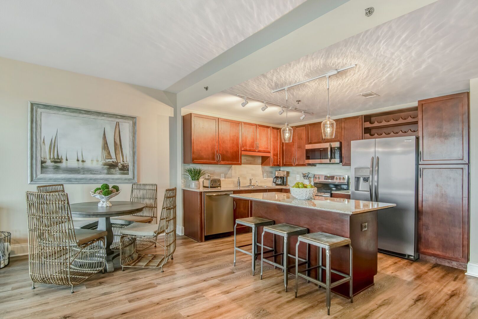 A modern kitchen with wooden cabinets, stainless steel appliances, and a central island with bar stools.