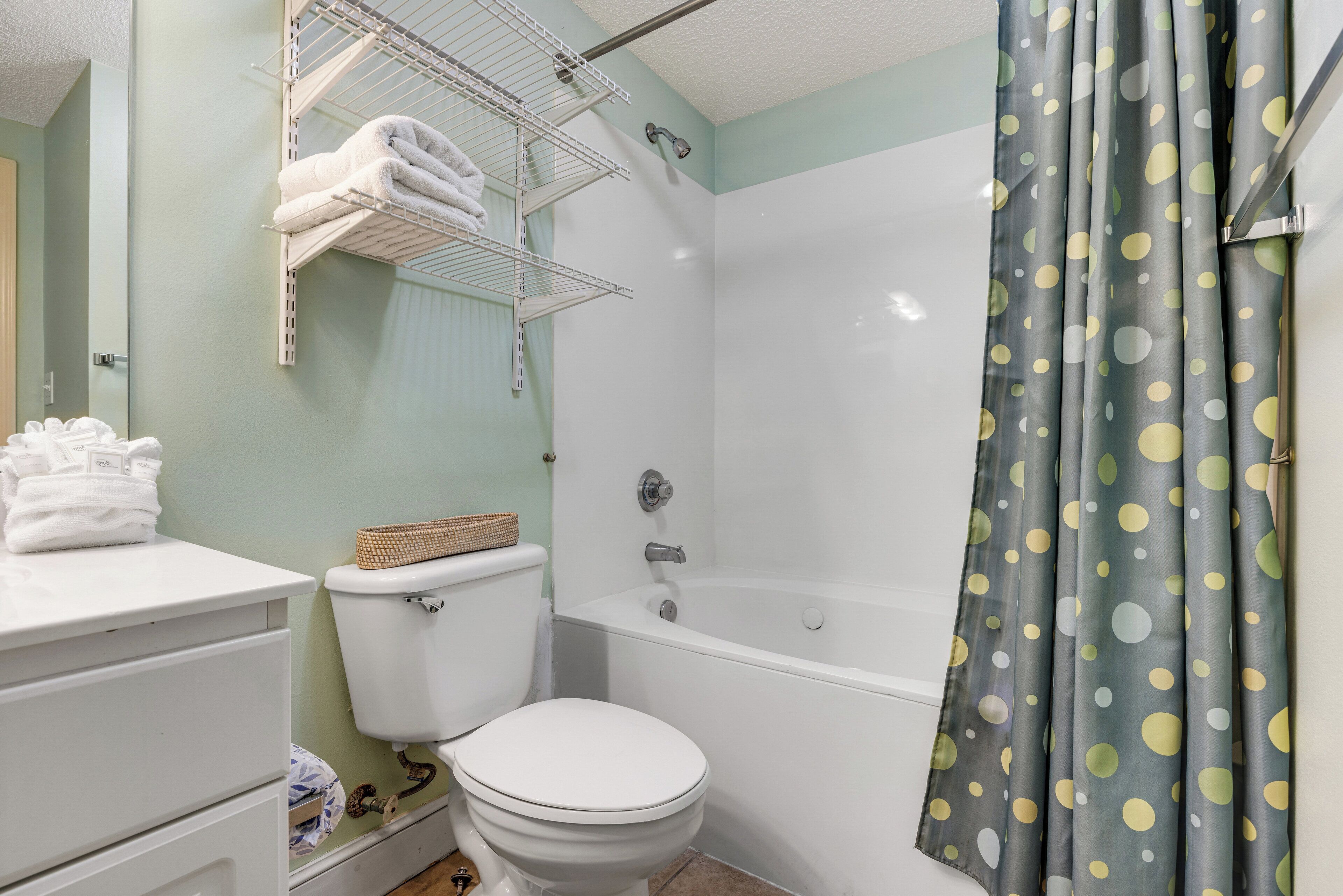 A bathroom with a toilet, a shower, a sink, and a towel rack.