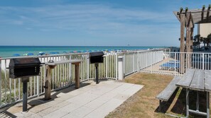 A beachside patio with a wooden pergola, a grill, and a mailbox. - Ocean Reef (Panama City Beach)