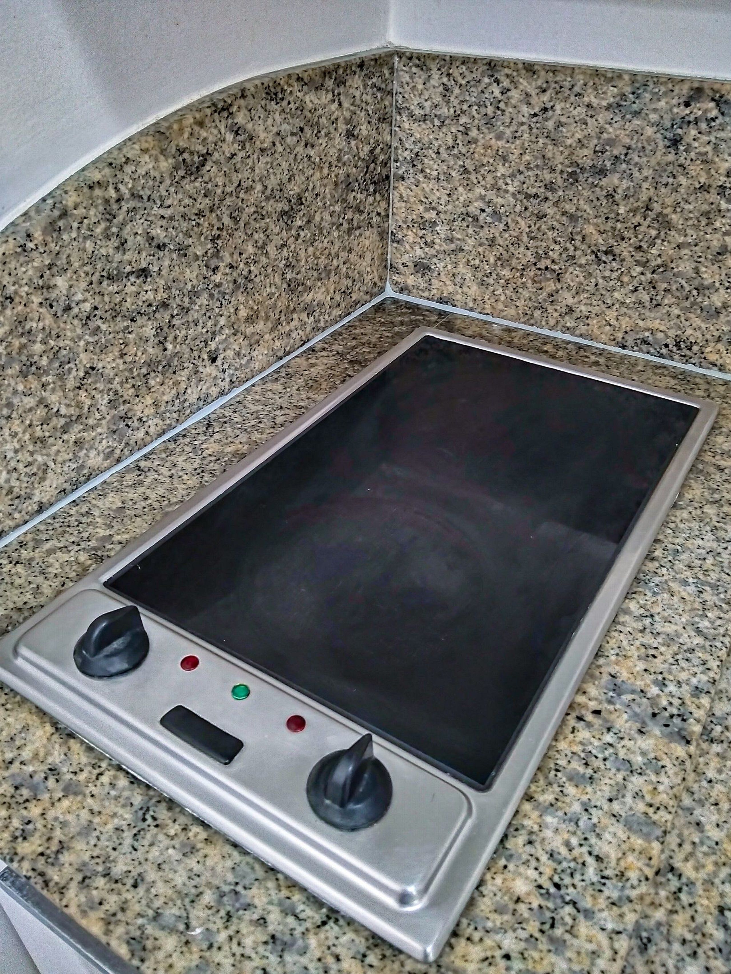 Eine Küche mit einer Granit Arbeitsplatte und einer integrierten Induktionskochplatte.