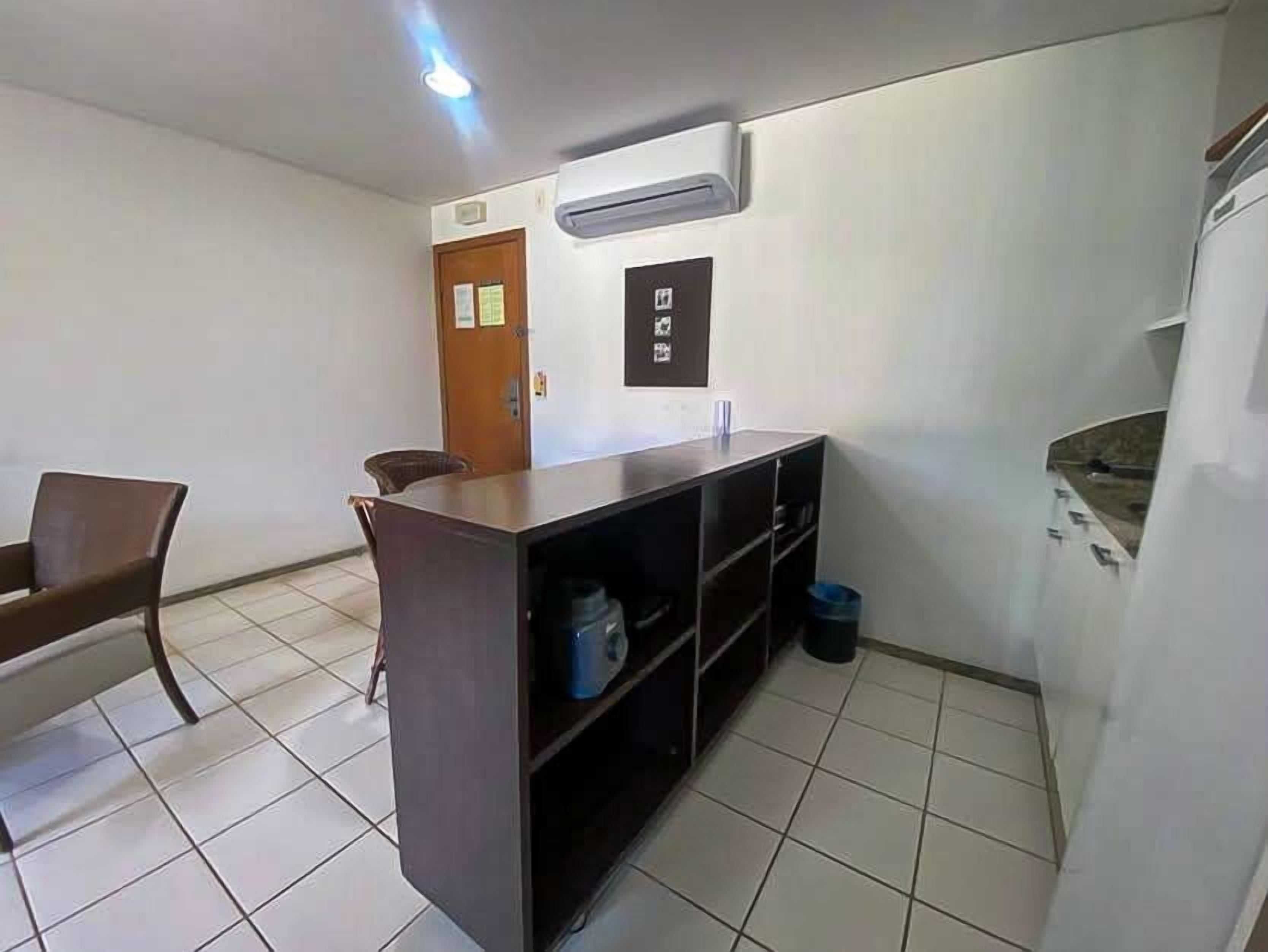 A small kitchenette with a countertop, chairs, a sink, and a door.