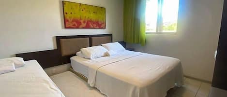 Une chambre d’hôtel avec deux lits, une tête de lit, un tableau au mur et une fenêtre avec des rideaux.