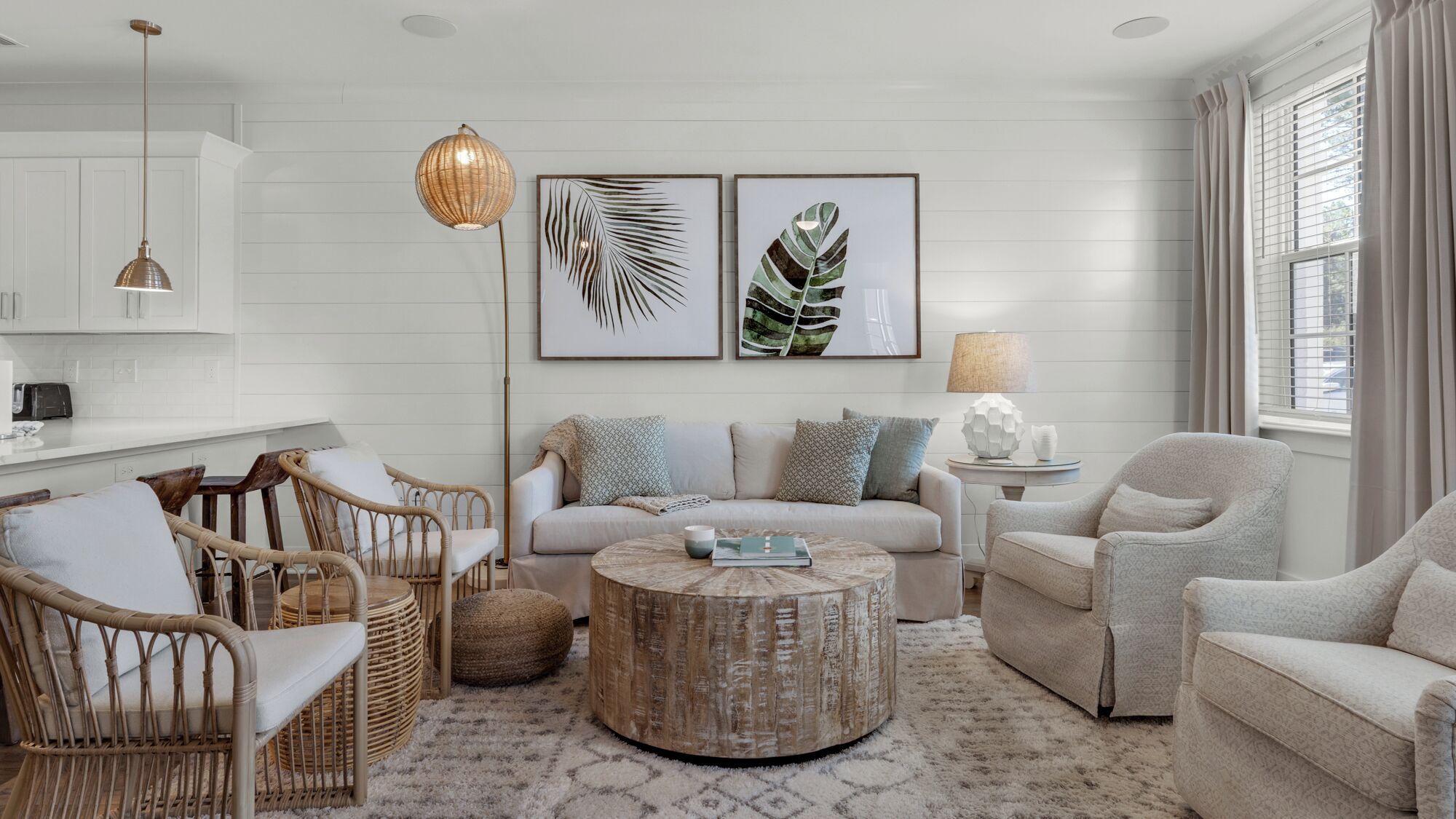 A living room with a sofa, chairs, a coffee table, and artwork on the wall.