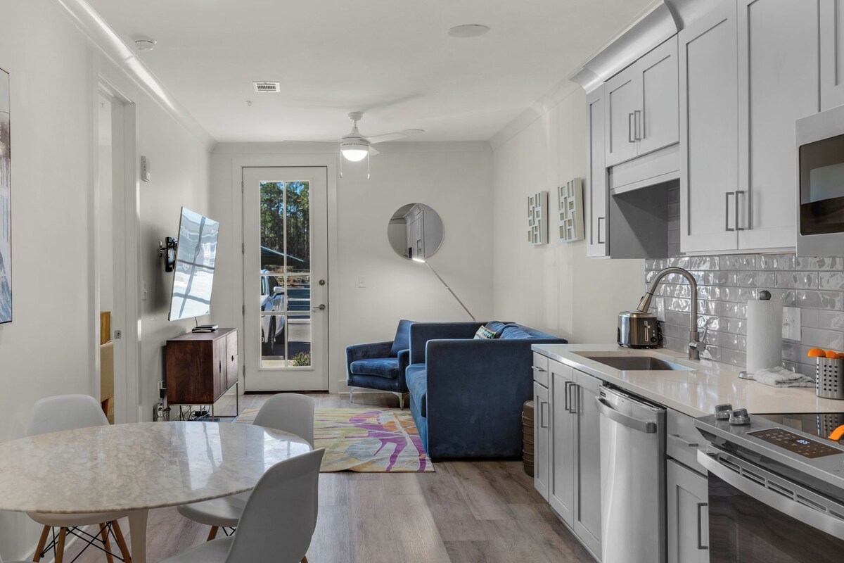 A modern kitchen with white cabinets, a built-in oven, and a stainless steel sink.