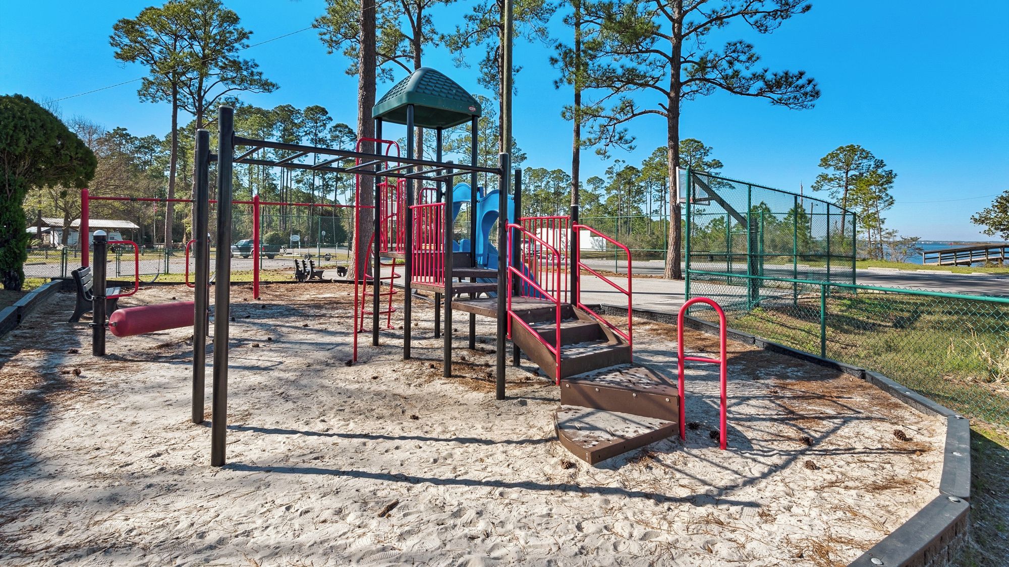 A playground with a climbing structure, slides, and a covered area.