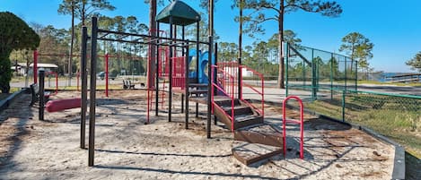 A playground with a climbing structure, slides, and a covered area.