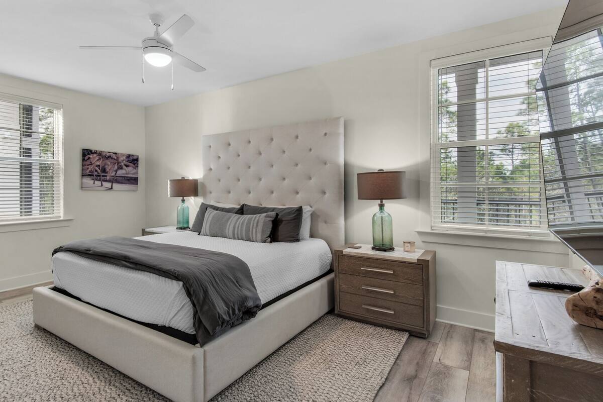 A bedroom with a bed, bedside tables, a desk, and a chair.